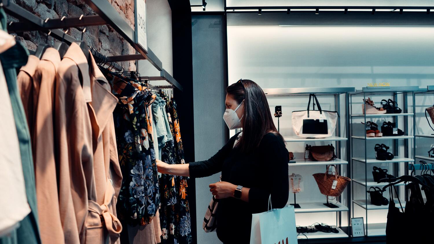 Un femme dans une boutique portant un masque contre le covid